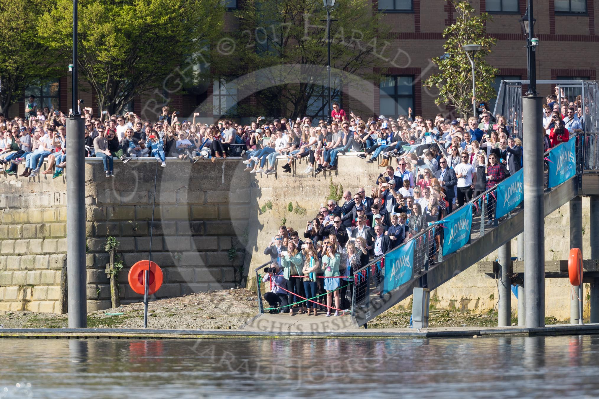 The Boat Race season 2017 -  The Cancer Research Women's Boat Race: Large crowds on the Thames Path at Fulham Reach - some might get wet when the flotilla has got past them.
River Thames between Putney Bridge and Mortlake,
London SW15,

United Kingdom,
on 02 April 2017 at 16:41, image #154