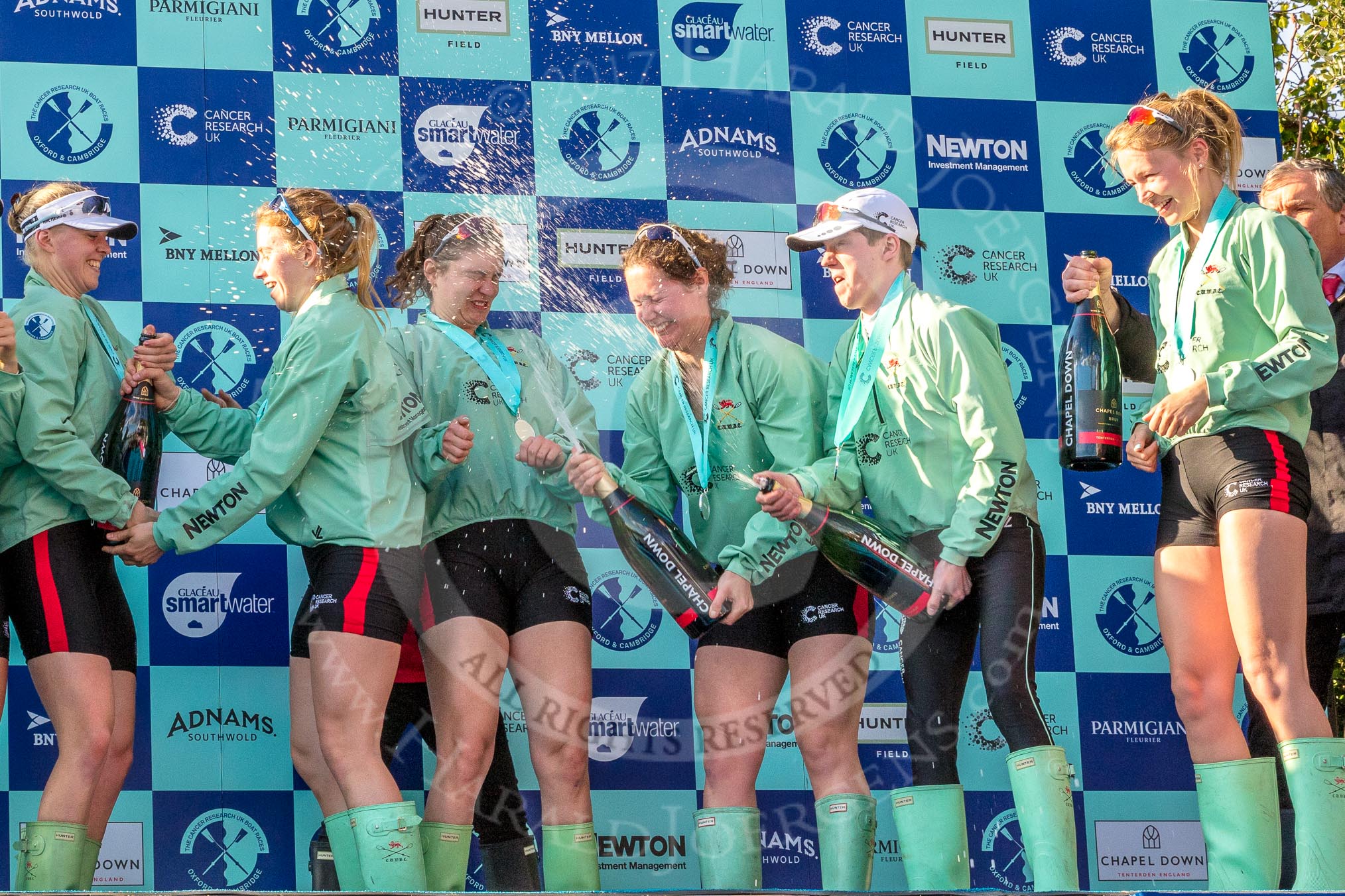 The Boat Race season 2017 -  The Cancer Research Women's Boat Race: CUWBC spraying the Champagne at the price giving - 5 seat Holly Hill, 6 seat Alice White, 7 seat Myriam Goudet, stroke Melissa Wilson, and cox Matthew Holland, and 4 seat Anna Dawson.
River Thames between Putney Bridge and Mortlake,
London SW15,

United Kingdom,
on 02 April 2017 at 17:13, image #256