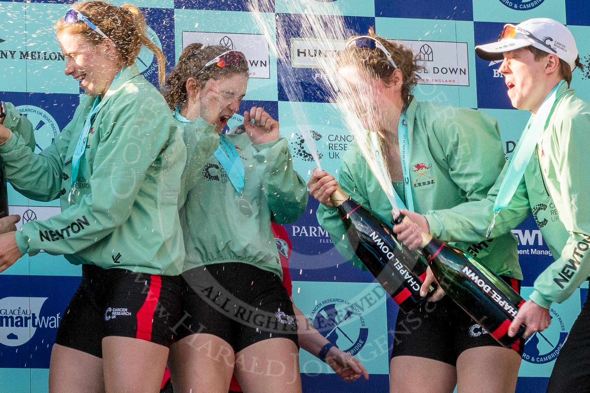 The Boat Race season 2017 -  The Cancer Research Women's Boat Race: CUWBC spraying the Champagne at the price giving - 6 seat Alice White, 7 seat Myriam Goudet, stroke Melissa Wilson, and cox Matthew Holland.
River Thames between Putney Bridge and Mortlake,
London SW15,

United Kingdom,
on 02 April 2017 at 17:13, image #259