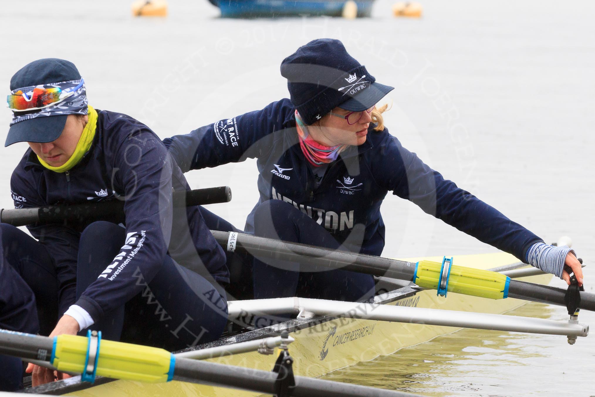 The Women's Boat Race season 2018 - fixture OUWBC vs. Molesey BC: OUWBC getting the boat ready on a cold and rainy day, here 2 seat Katherine Erickson and bow Renée Koolschijn.
River Thames between Putney Bridge and Mortlake,
London SW15,

United Kingdom,
on 04 March 2018 at 13:05, image #4