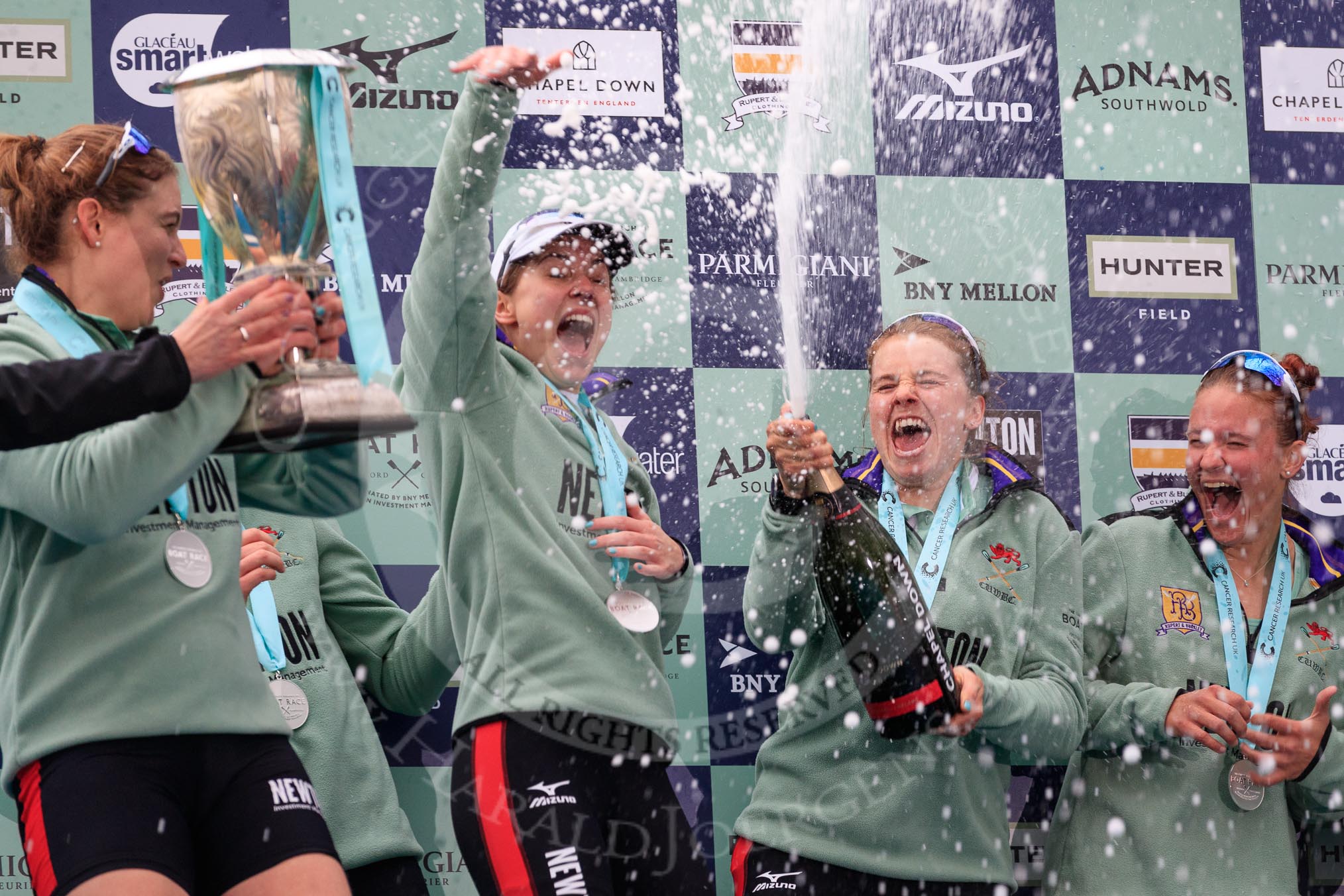 The Cancer Research UK Women's Boat Race 2018: The Cambridge women celebrating with their Boat Race medals, the Women's Boat Race trophy, and lots of Chapel Down Brut: Myriam Goudet-Boukhatmi, Sophie Shapter, Alice White, Paula Wesselmann.
River Thames between Putney Bridge and Mortlake,
London SW15,

United Kingdom,
on 24 March 2018 at 17:09, image #279