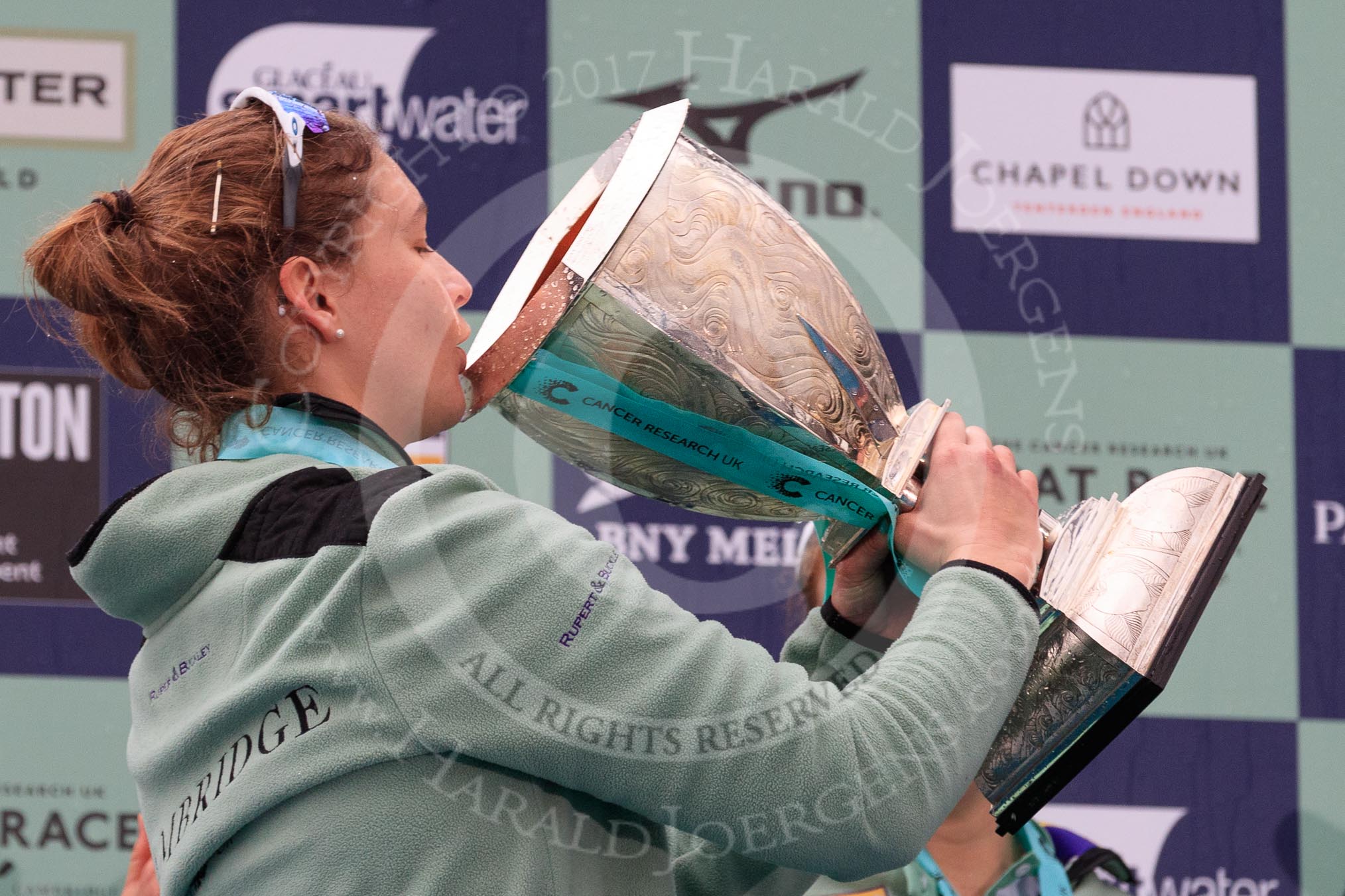 The Cancer Research UK Women's Boat Race 2018: Cambridge 7 seat Myriam Goudet-Boukhatmi drinking champagne out of the Women's Boat Race trophy.
River Thames between Putney Bridge and Mortlake,
London SW15,

United Kingdom,
on 24 March 2018 at 17:09, image #290