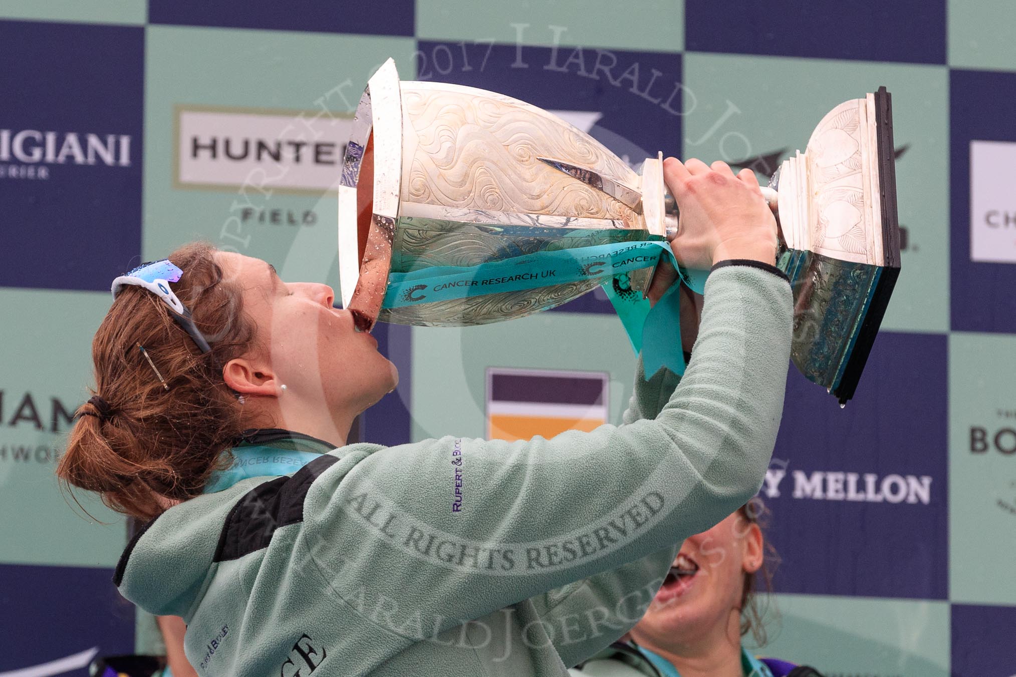 The Cancer Research UK Women's Boat Race 2018: Cambridge 7 seat Myriam Goudet-Boukhatmi drinking champagne out of the Women's Boat Race trophy.
River Thames between Putney Bridge and Mortlake,
London SW15,

United Kingdom,
on 24 March 2018 at 17:09, image #291