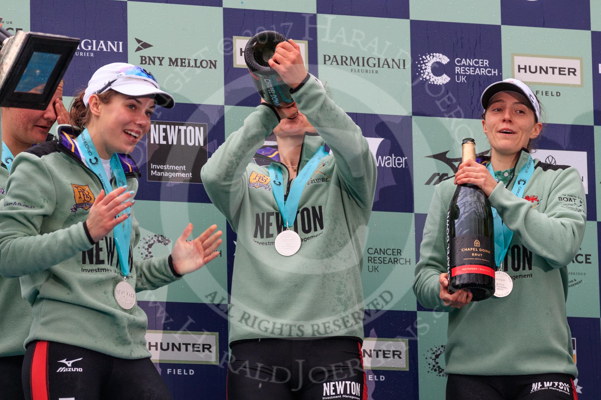 The Cancer Research UK Women's Boat Race 2018: The Cambridge women celebrating with their Boat Race medals, the Women's Boat Race trophy, and lots of Chapel Down Brut: Sophi Shapter,  Thea Zabell, Kelsey Barolak,.
River Thames between Putney Bridge and Mortlake,
London SW15,

United Kingdom,
on 24 March 2018 at 17:09, image #292