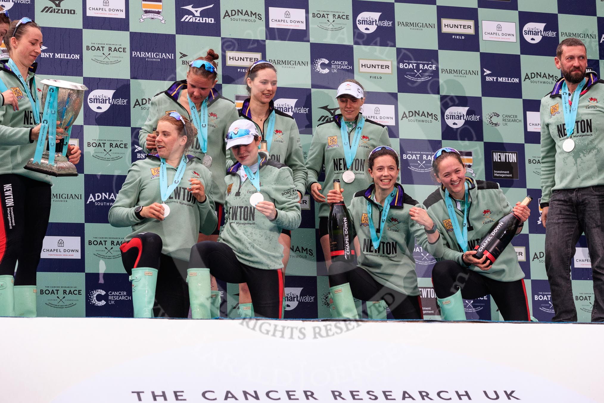 The Cancer Research UK Women's Boat Race 2018: The Cambridge women celebrating with their Boat Race medals, the Women's Boat Race trophy, and lots of Chapel Down Brut: Olivia Coffey  (with the trophy). Paula Wesselmann,  Thea Zabell, Kelsey Barolak, CUWBC Head Coach Rob Baker, and, on their knees, Alice White, Sophie Shapter, Imogen Grant, and Tricia Smith.
River Thames between Putney Bridge and Mortlake,
London SW15,

United Kingdom,
on 24 March 2018 at 17:09, image #295