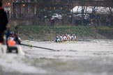 The Cancer Research UK Women's Boat Race 2018: Near the White Hart pub in Barnes, the Oxford boat, on the left, is almost hidden behind the umpires's launch. In the leading Cambridge boat cox Sophie Shapter, stroke Olivia Coffey, 7 Myriam Goudet-Boukhatmi, 6 Alice White, 5 Paula Wesselmann, 4 Thea Zabell, 3 Kelsey Barolak, 2	Imogen Grant, bow Tricia Smith.
River Thames between Putney Bridge and Mortlake,
London SW15,

United Kingdom,
on 24 March 2018 at 16:47, image #199