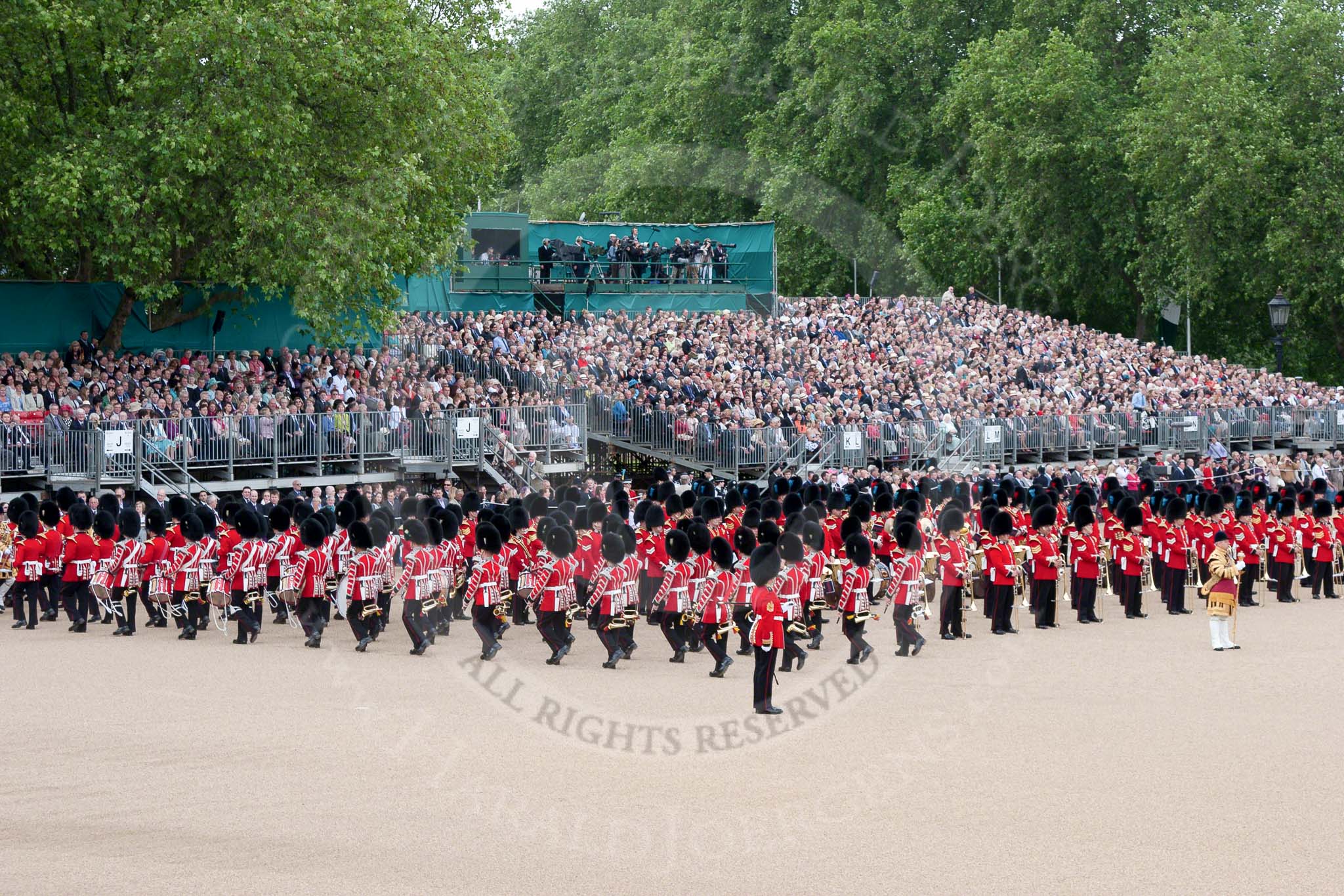 Trooping the Colour 2010: The Band of the Grenadier Guards is marching into their starting position for the parade.

The Colour Sergeant (bottom middle) is observing the proceedings.

The bands of the Irish Guards (blue plumes on the bearskins) and Coldstream Guards (red plumes) have already taken their positions.

The public stands behind the bands are at the rear of the garden of No. 10 Downing Street..
Horse Guards Parade, Westminster,
London SW1,
Greater London,
United Kingdom,
on 12 June 2010 at 10:32, image #17