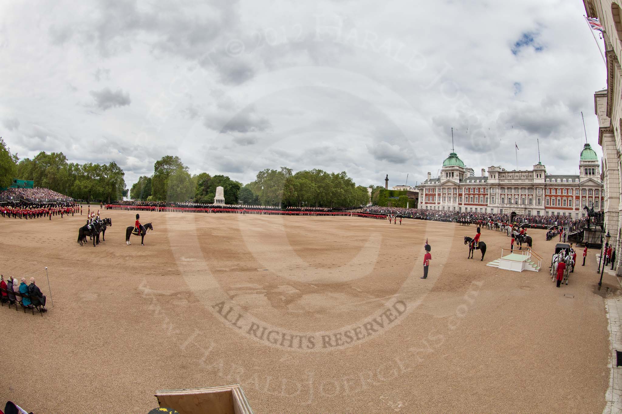 The Colonel's Review 2012: Another overview of Horse Guards Parade. On the very left the Massed Bands, also on the left Brigade Major Household Division, Lieutenant Colonel A P Speed, Scots Guards, and four Troopers of The Blues and Royals. On the right the saltung base for HM the Queen, behind the "Royal Procession". In front of the Guards Memorial No. 1 - No. 6 Guard..
Horse Guards Parade, Westminster,
London SW1,

United Kingdom,
on 09 June 2012 at 10:59, image #165