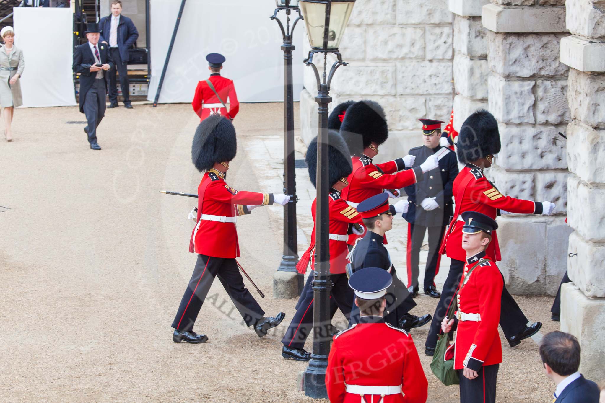 Trooping the Colour 2013: The 'Keepers of the Ground', guardsmen bearing marker flags for their respective regiments, disappearing under Horse Guards Arch, they will return later to mark the positions for their regiments. Image #27, 15 June 2013 09:55 Horse Guards Parade, London, UK