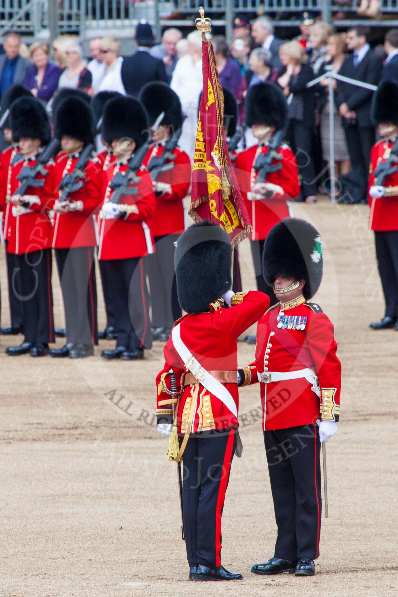 Trooping the Colour 2013: The Ensign, Ensign, Second Lieutenant Joel Dinwiddle, takes posession of the Colour from the Regimental Sergeant Major, WO1 Martin Topps, Welsh Guards. Image #457, 15 June 2013 11:21 Horse Guards Parade, London, UK