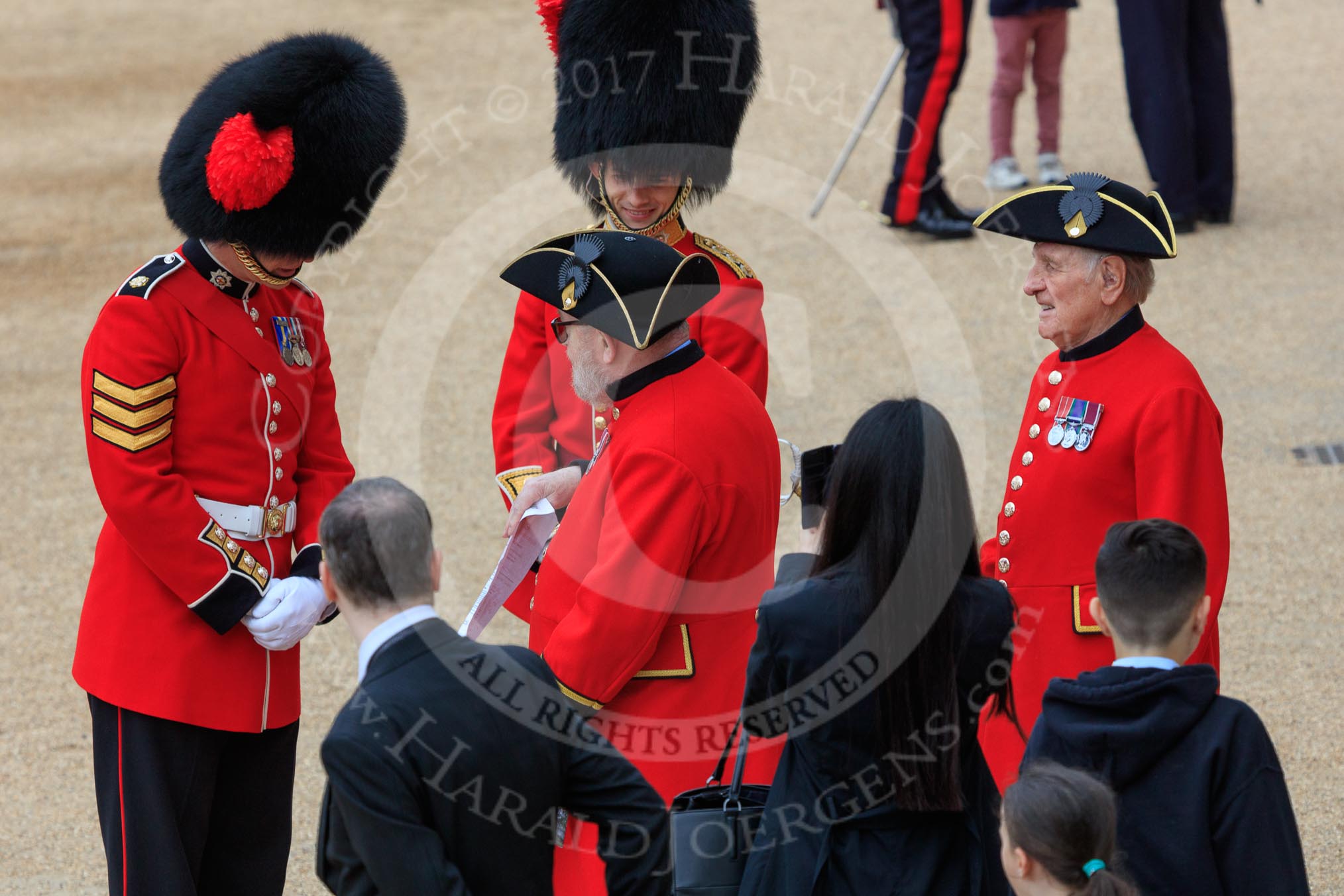 A Coldstream Guards Sergeant and Captain welcoming Chelsea Pensioners before The Colonel's Review 2018 (final rehearsal for Trooping the Colour, The Queen's Birthday Parade)  at Horse Guards Parade, Westminster, London, 2 June 2018, 09:19.
