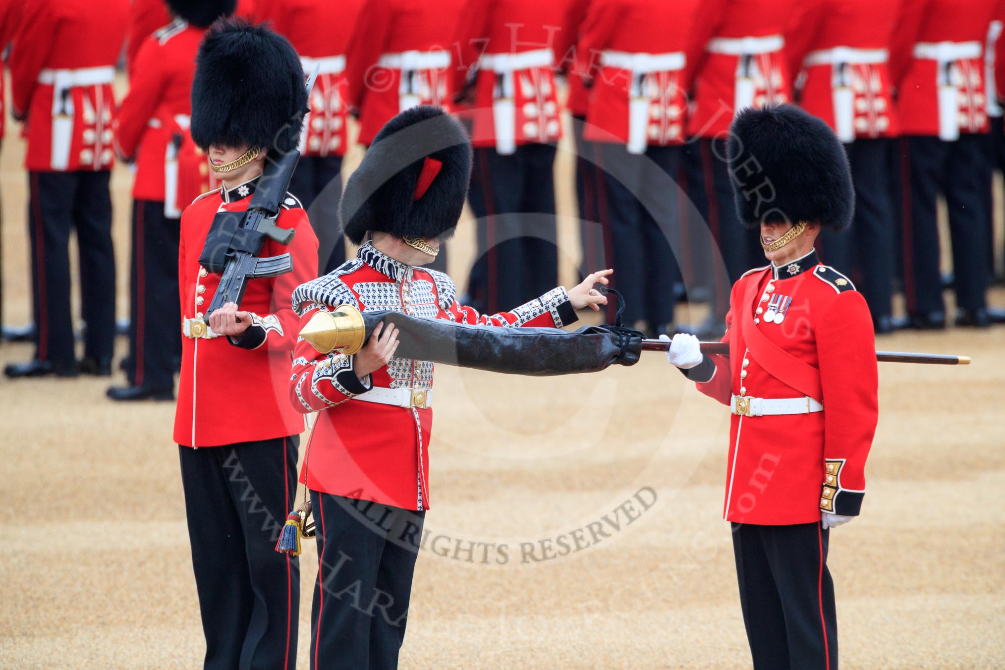 Duty Drummer  Sam Orchard uncasing the Colour held by Colour Sergeant Sam McAuley (31), with Colour Sentry Guardsman Jonathon Hughes (26) behind, during The Colonel's Review 2018 (final rehearsal for Trooping the Colour, The Queen's Birthday Parade)  at Horse Guards Parade, Westminster, London, 2 June 2018, 10:33.