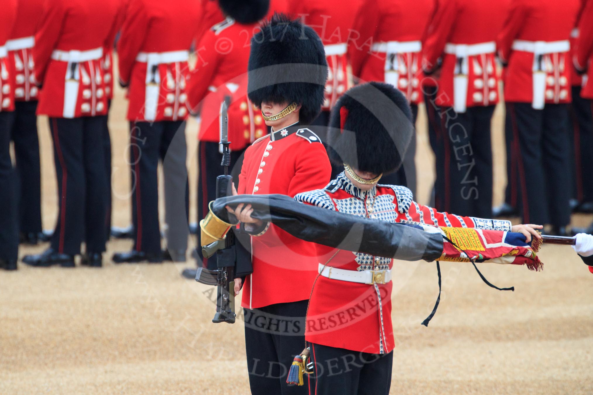 Duty Drummer  Sam Orchard uncasing the Colour. Behind him Colour Sentry Guardsman Jonathon Hughes (26) during The Colonel's Review 2018 (final rehearsal for Trooping the Colour, The Queen's Birthday Parade)  at Horse Guards Parade, Westminster, London, 2 June 2018, 10:33.
