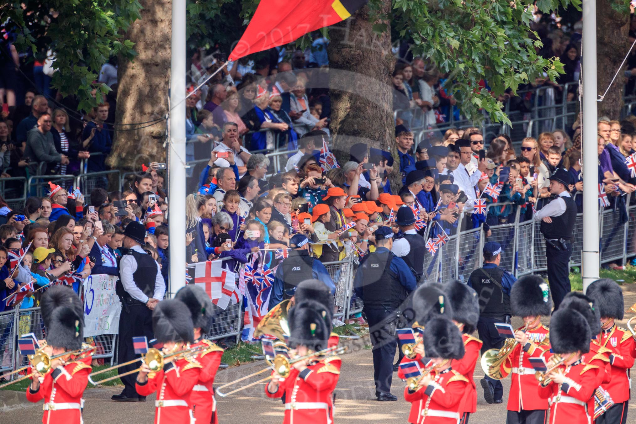 The crowded Youth Enclosure, with the Band of the Welsh Guards marching past, before Trooping the Colour 2018, The Queen's Birthday Parade at Horse Guards Parade, Westminster, London, 9 June 2018, 10:12.