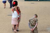 Two young ladies, wearing fascinators, posing with Coldstream Guards officer for a photo before Trooping the Colour 2018, The Queen's Birthday Parade at Horse Guards Parade, Westminster, London, 9 June 2018, 09:02.